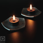 Pair of wrought iron candle holders with flaming tealight candle